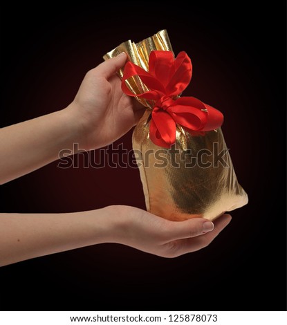 two women's hands are holding a bag of gifts