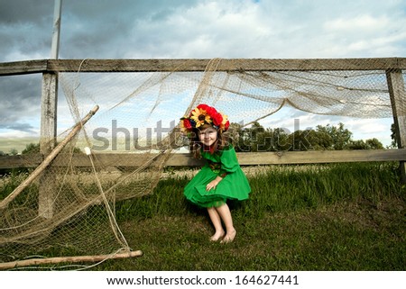 little beauty in the national Ukrainian costume on the background of a fishing net