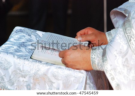 Hands of the priest with the Bible