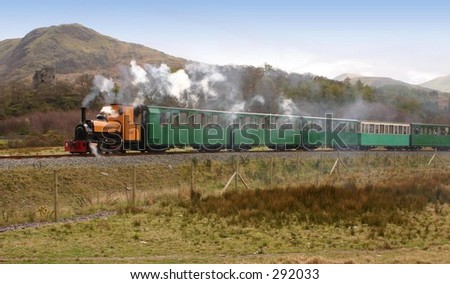 Steam train with mountain side castle in the distance
