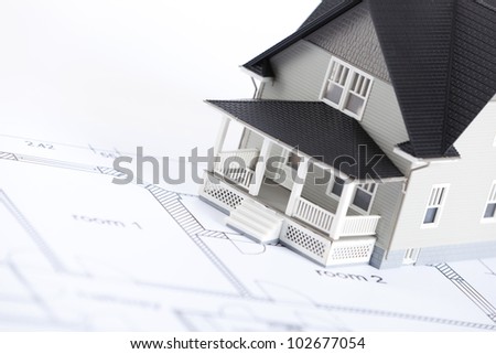 Real estate concept - construction plan with  house architectural model on it