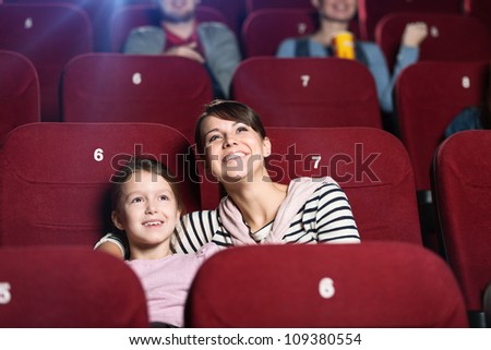 A girl with mother spending time together at the cinema