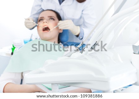 Dentist\'s assistant checks up the teeth of the patient.