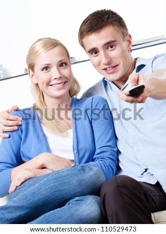 Sitting on the couch couple are going to watch TV set