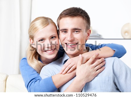 Smiley couple rests on the white leather sofa