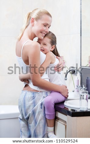 Mother and daughter embrace each other in bathroom