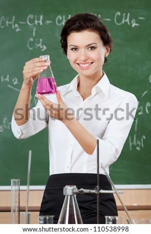 Smiley chemistry teacher hands an Erlenmeyer flask with pink liquid