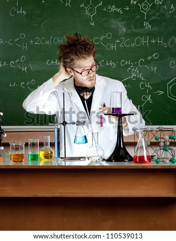 Mad professor scratches his head working in his laboratory