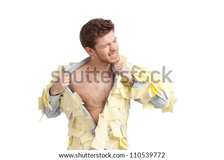 A young male ripping off his shirt, covered with stickers, isolated on white on white