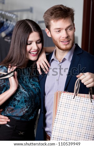 Wonderful couple is in the shopping mall and happy that they bought a lot of things at cut rates