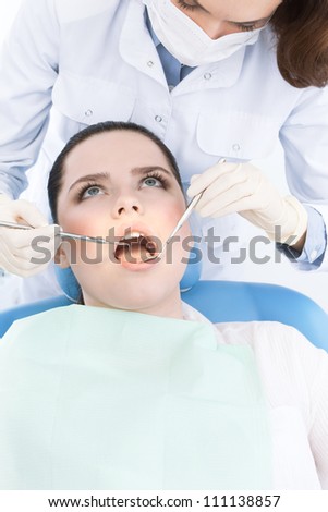 Dentist\'s assistant checks the teeth of the patient