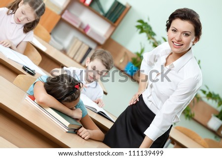 Tired schoolgirl sleeps at the school desk