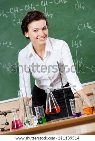 Smiley chemistry teacher is ready to start an experiment using different flasks and beakers