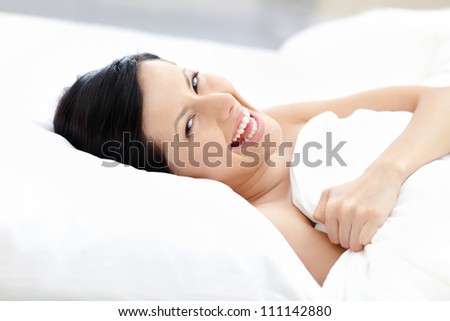 Laughing woman tries to fall asleep lying on the pillow