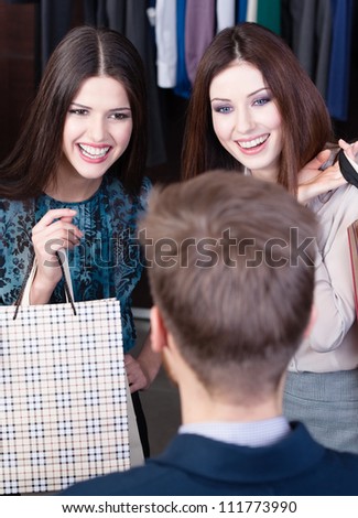 Two girls speak to salesperson