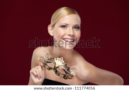Pretty woman with patterned masquerade mask, isolated on purple
