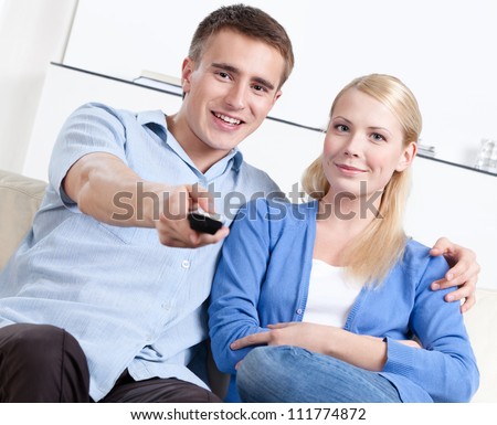 Man holds remote control and is going to watch TV set