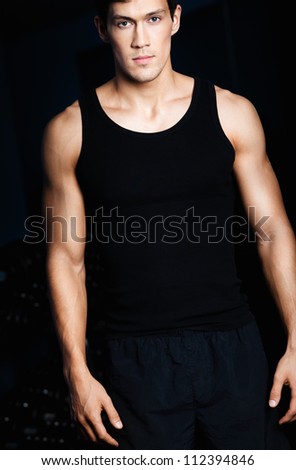 Portrait of a serious sportive man in sportswear isolated on black background