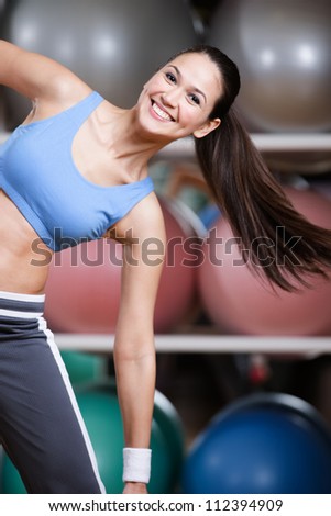 Sportswoman training with dumbbells in gym developing muscles