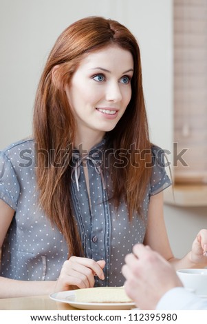 Lady talks with someone sitting at the table at the restaurant