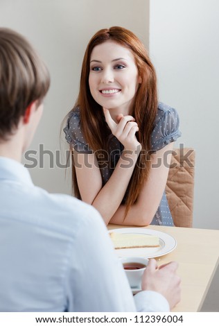 Woman talks with man sitting at the table at the bar