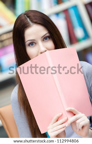 Female student reads the book at the library. Study