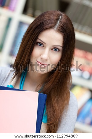 Female student with books at the library. Research. Education and research