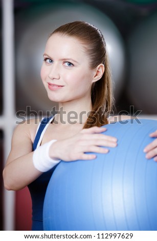 Woman with blue gym ball in fitness gym