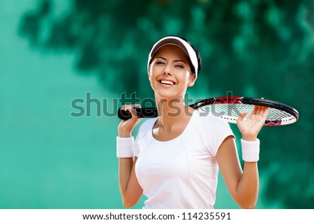 Successful sportswoman with racket at the tennis court. Healthy lifestyle