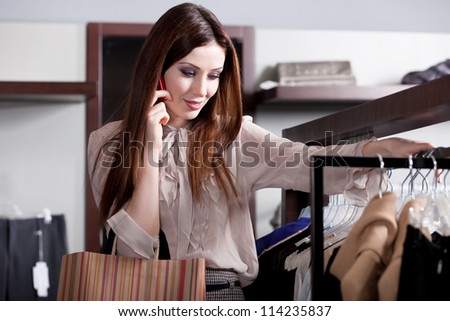 Speaking on the phone and choosing clothes in the store