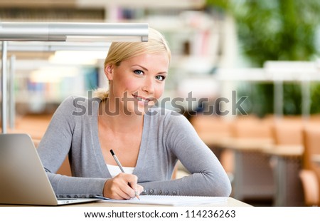 Female student working on the computer sitting at the desk. Process of studying