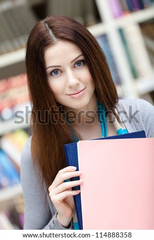 Female student with books at the library. Research. Knowledge