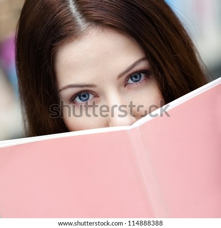 Female student reads the book at the library. Knowledge - stock photo