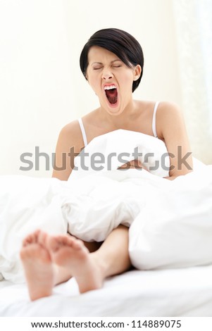 Halfnaked woman is yawning, isolated on white background