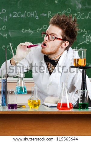 Mad professor tastes the pink liquid in the vial in his laboratory