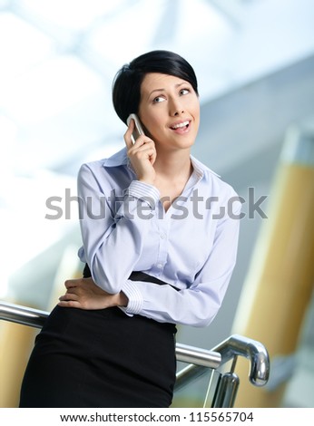 Business woman in business suit talks on cellular phone. Communication