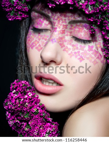 Close up portrait of model with flowered wreath and fashion make-up with eyes shut