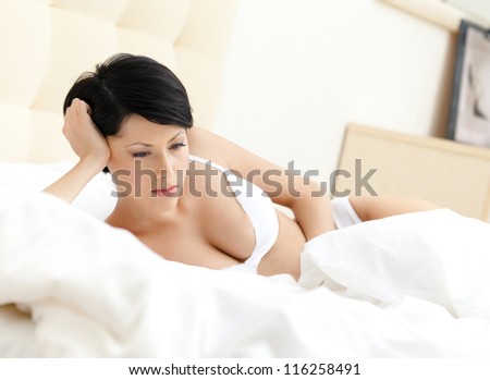 Woman in underwear is lying in the comfortable bed