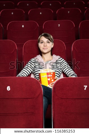 Young woman watching a movie alone at the cinema