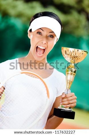 Young female tennis player won the cup at the sport competition. Victory