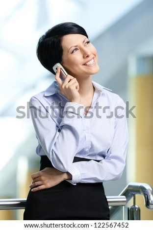 Business woman in business suit talks on cellphone. Communication