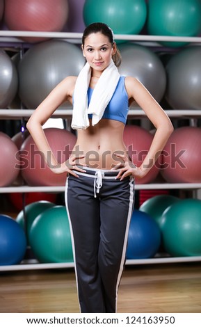 Loosing weight woman in fitness gym with shelves of gym balls