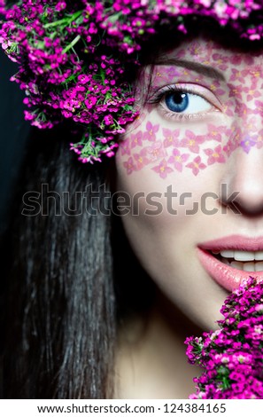 Portrait of young beautiful fresh girl\'s half face with stylish make-up and pink flowers