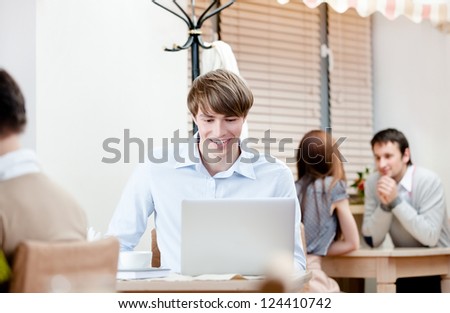 Man is working on the personal computer sitting at the coffee house