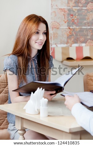 Woman hands the menu choosing a dish to make an order