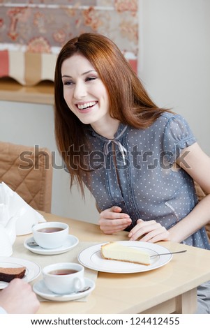 Woman talks with someone sitting at the table at the restaurant