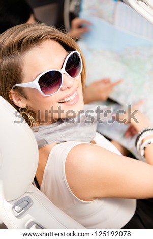 Girl lost the way and checks the way with the help of the highway map sitting in the car