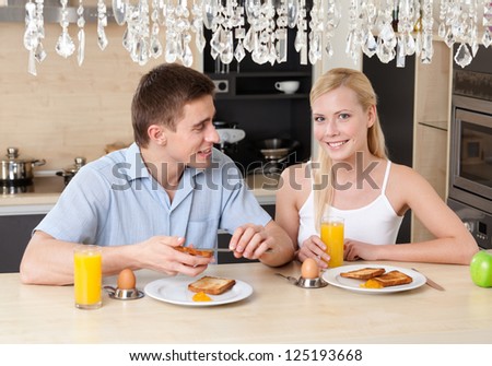 Husband and wife have breakfast in the modern comfortable kitchen