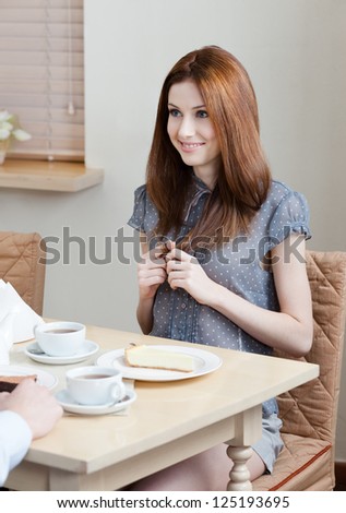 Woman talks with someone sitting at the table at the bar
