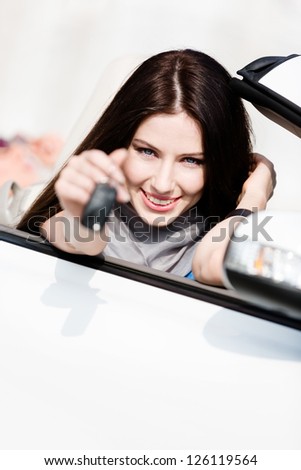 Girl in the cabriolet shows car key. Buying car and getting the freedom